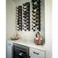 Wine bottle pin rack on wall with multiple bottles on black rails