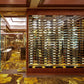 Double-sided wine rail system with many bottle slots in a wood-paneled display area