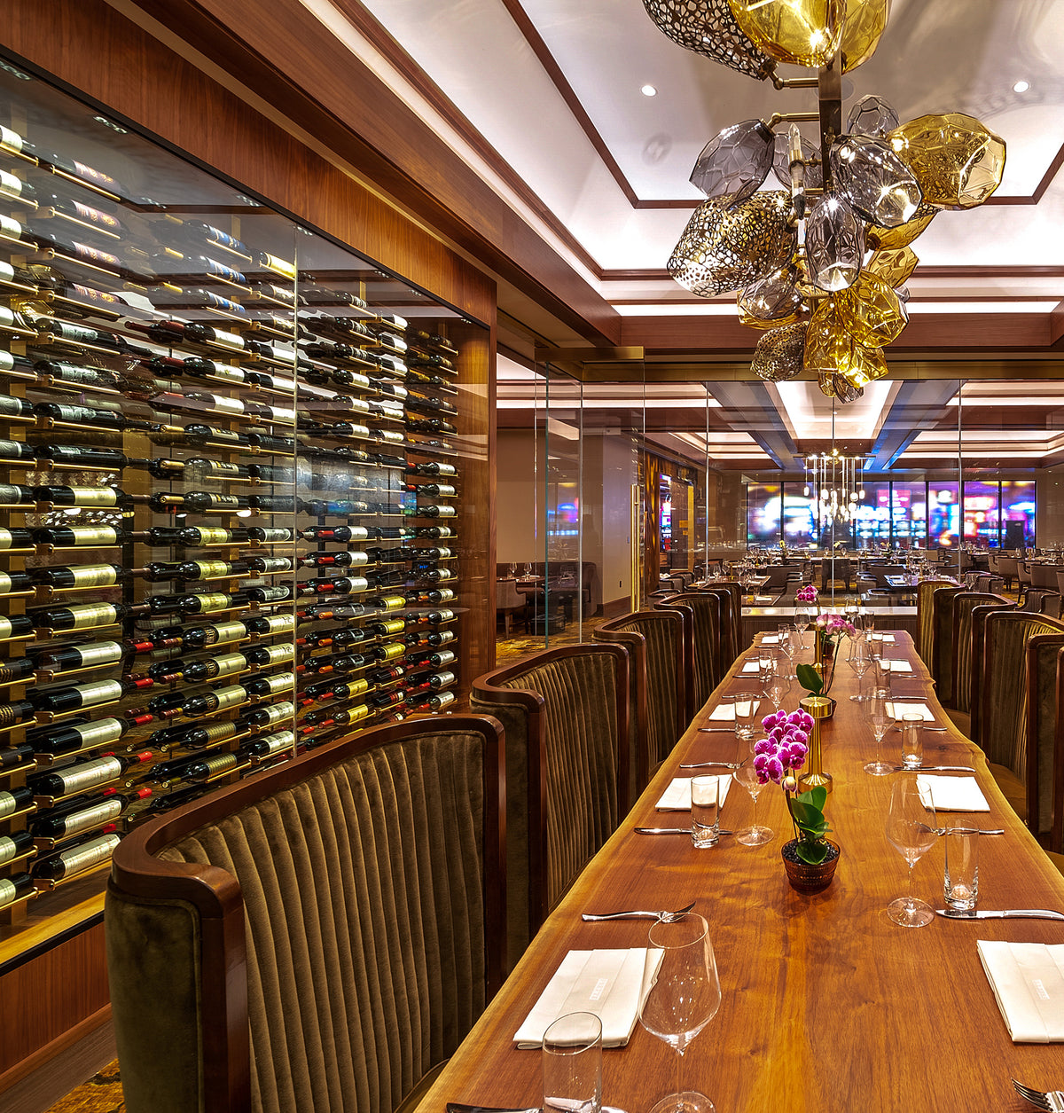 Double-sided bottle display rails along a long bar, with bottle rows on glass panels