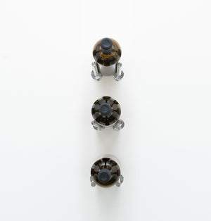 Wall-mounted 3-bottle rail with three clear bottle-holder caps and a dark metal base