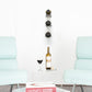 Wall wine bottle display rail holding three bottles with purple neck caps