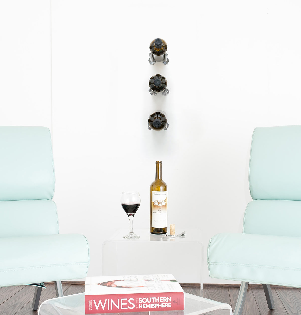 Wall wine bottle display rail holding three bottles with purple neck caps