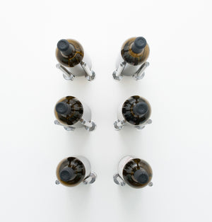 Wine rail designer grid with six bottle holders, silver metal caps on amber bottles