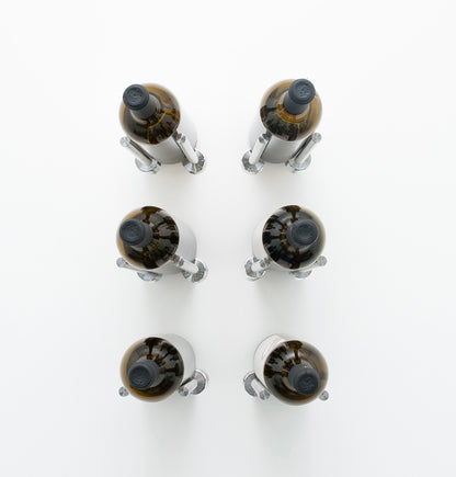 Wine rail designer grid with six bottle holders, silver metal caps on amber bottles