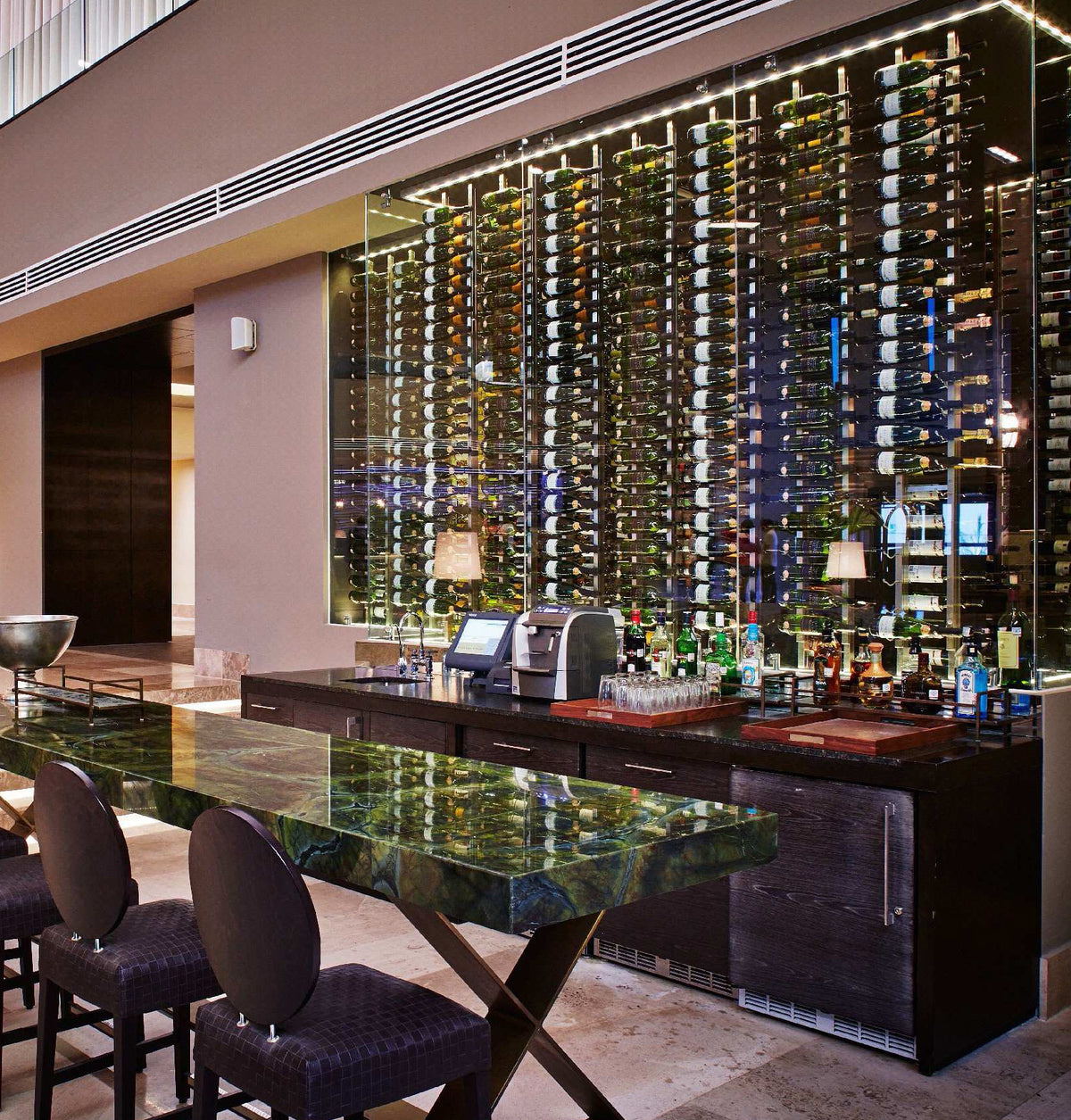 Wall-mounted wine bottle display with illuminated rails and floating frame design
