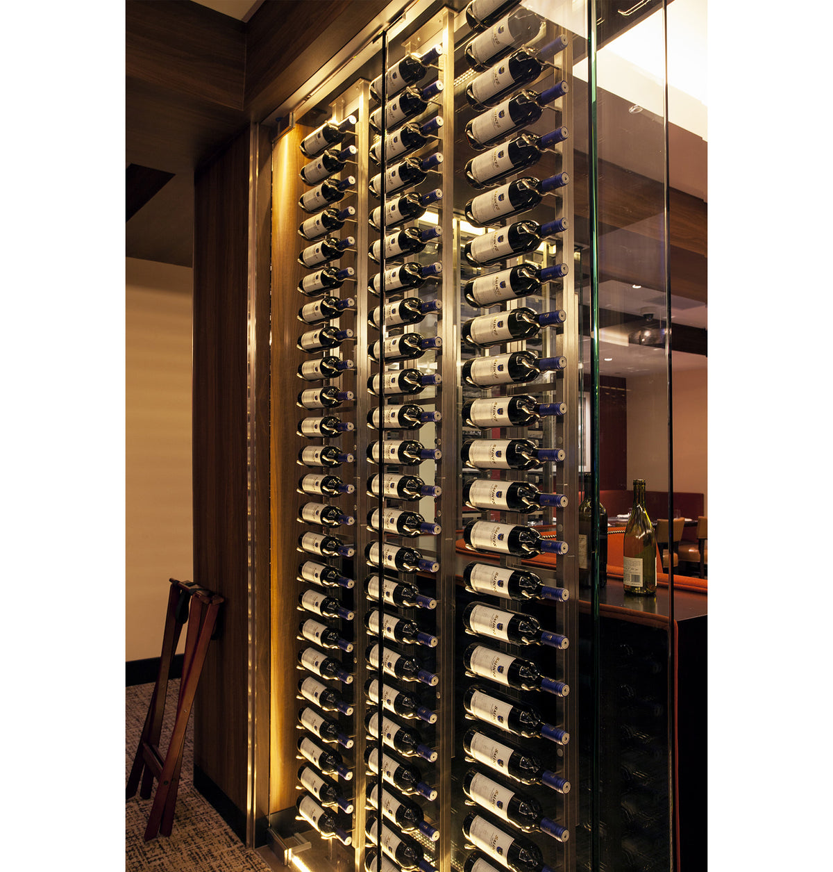 Wall wine rack system with black frame and multiple wine bottles installed
