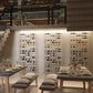Wine display wall with multiple clear shelves holding bottles, set in a showroom