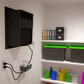 Through-wall wine cellar cooling system with wall-mounted black grille and cables