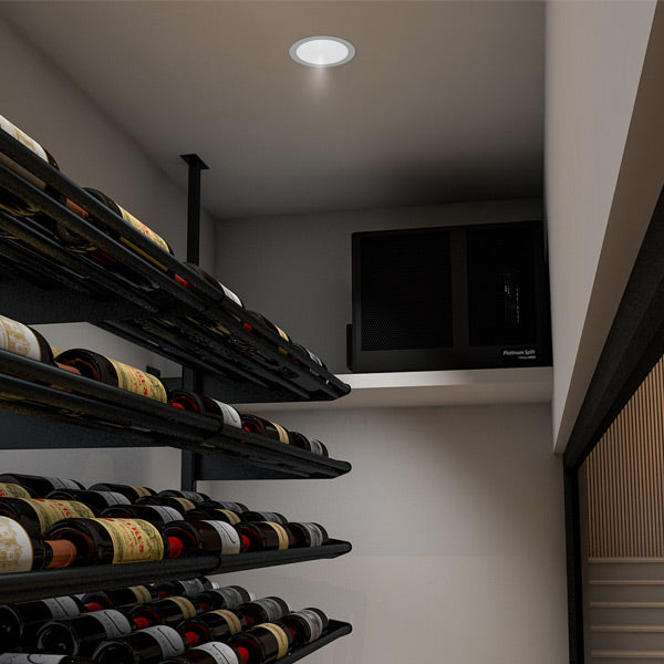 Wall-mounted WhisperKOOL controller with blue display beside wine bottle storage shelves