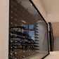 Wine cellar interior with bottle racks and glass-door display space under ceiling lights