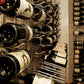 Close-up of bottle necks in metal holders along the wine rack