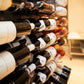 Wine bottle display in wall-mounted rack with multiple bottles, close-up