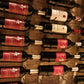 Wall-mounted wine rack holding red and white wine bottles, close-up on holders.