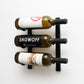 Wall-mounted wine rack with three wine bottles in black metal holders