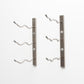 Wall-mount wine rack with brushed metal bars and white curved bottle pegs