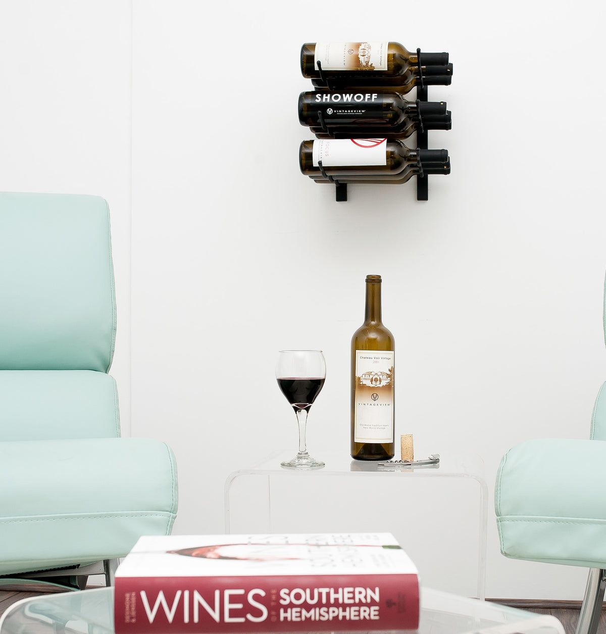 Wall wine rack with three bottle slots mounted on wall, holding a single wine bottle