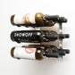 Wall-mounted wine rack with three bottle cradles holding assorted wine bottles