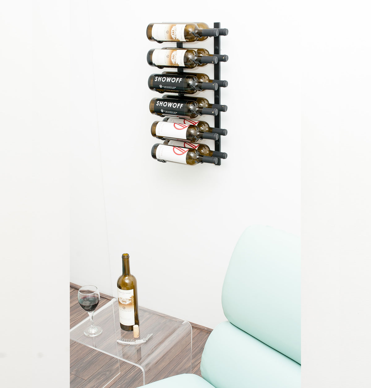 Wall wine rack with black pegs holding multiple wine bottles