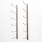 Wall-mounted wine rack with empty curved bottle holders on bronze-colored metal bars