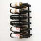 Wall wine rack with silver back and black pegs holding six wine bottles