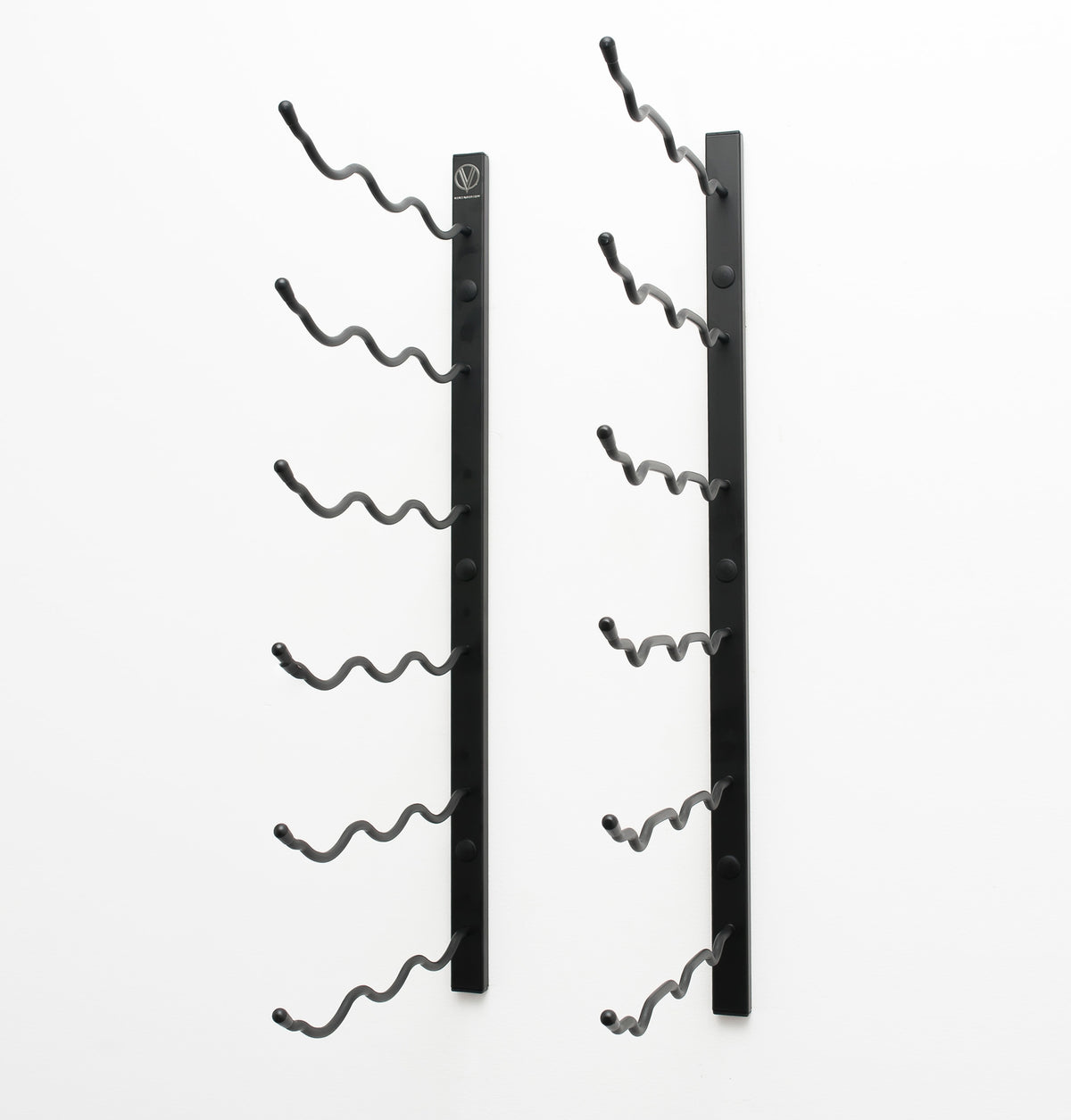 Wall-mounted wine rack with empty curved bottle holders on matte black metal bars