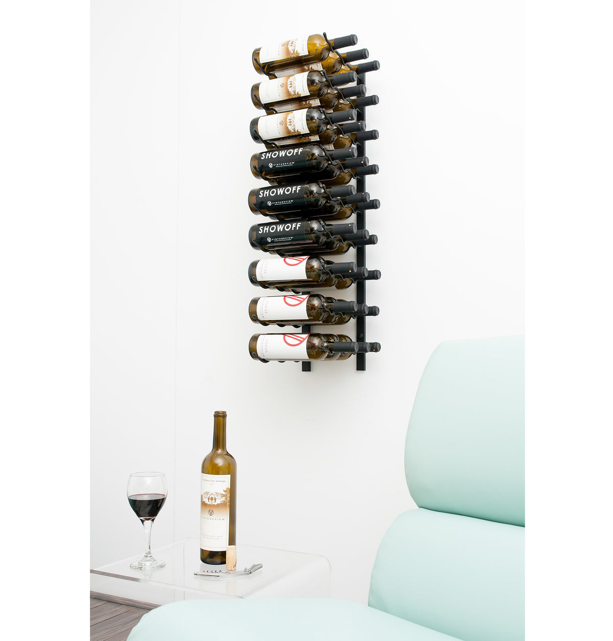 Wall-mounted black wine rack holding wine bottles in several rows.