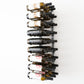 Wall-mounted black wine rack holding wine bottles with necks supported by round pegs.