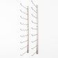 Wall-mounted light gray wine rack with curved bottle holders, empty.