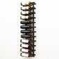 Wall-mounted wine rack holding bottles in black metal rows