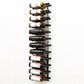 Wall-mounted wine rack with black bottle holders arranged in rows