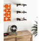 Wall-mounted wine bottle rack with black metal rails holding horizontal bottles