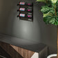 Wall wine bottle rack with three bottles above a console and potted plant