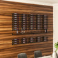 Wall-mounted wine bottle rack with multiple rows of bottles in a black frame