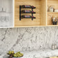 Cabinet wall wine rack with black frame holding three bottles in open cubby