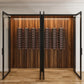 Wine bottle storage rack inside open wood cabinet with black rails and rows of bottles