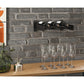 Black wall-mounted cork wine bottle ledge holding several wine bottles
