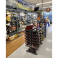 Double-sided wine bottle display rack with shelf, black metal, in retail store on casters