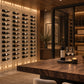 Cable wine rack wall with many hanging bottles and golden bronze hardware rails