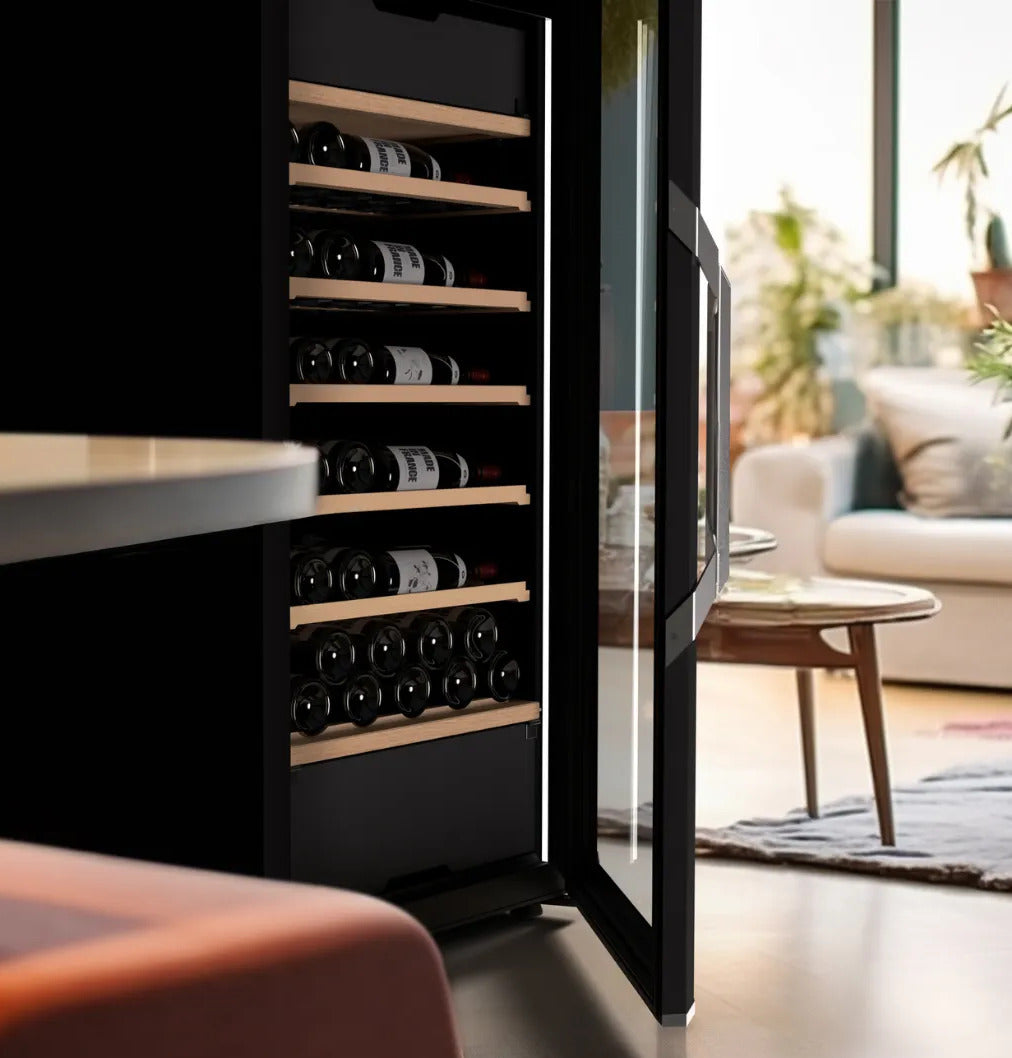 Open black wine fridge showing wooden shelves filled with wine bottles