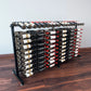 Double-sided wine bottle display rack with black frame and bottle holders on both sides.