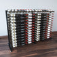 Double-sided wine bottle display rack with black frame holding rows of bottles.