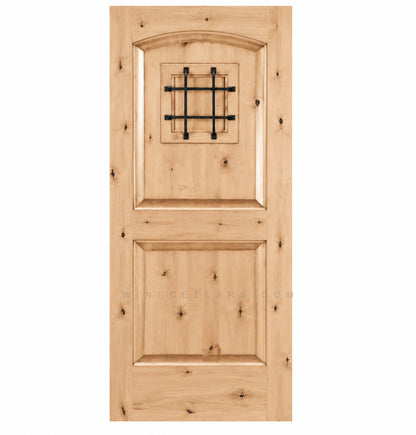 Light pine-style wine cellar door with arched top, iron speakeasy grille, and recessed panels