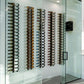 Wall wine peg rails displaying bottles on black peg holders
