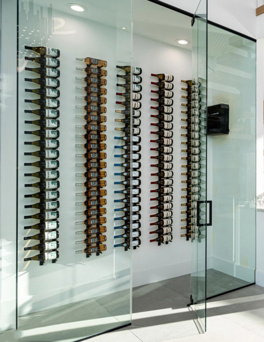 Wall wine peg rails displaying bottles on black peg holders