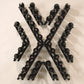 Black metal wine rack in an X shape with cork-out bottle pegs