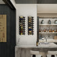 Wall-mounted metal wine rack holding dark wine bottles against a wall