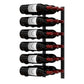 Wall-mounted metal wine rack holding dark wine bottles with visible labels and red corks