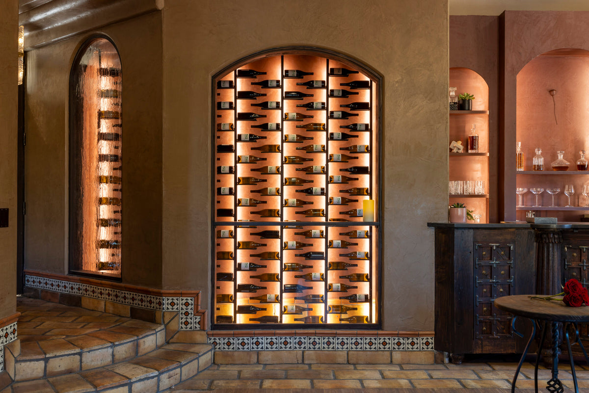 Arched wall wine bottle rack with black pegs, filled with bottles