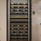 Glass-front wine storage display with black rails holding rows of wine bottles