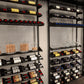 Wall wine display shelves with stacked bottles, glassware, and corked storage cups